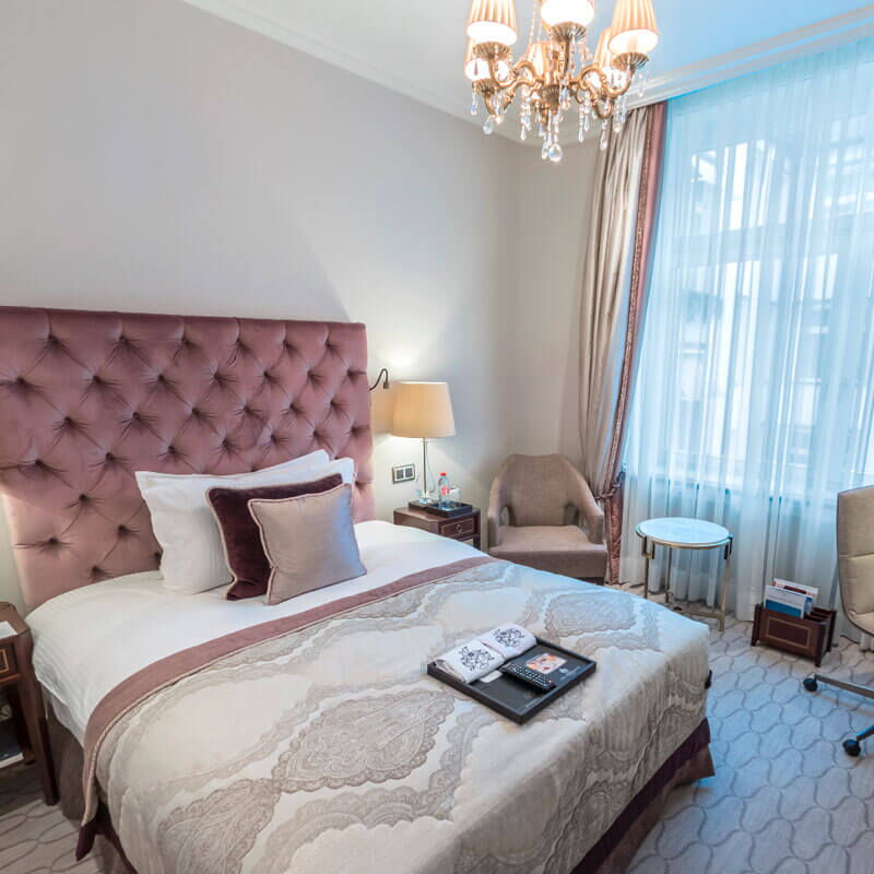 Rosa dekoriertes Bett im Einzelzimmer des Hotel Vier Jahreszeiten in Hamburg