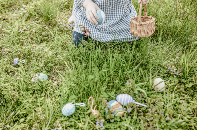 Decorative Easter eggs in a meadow with a child in the background