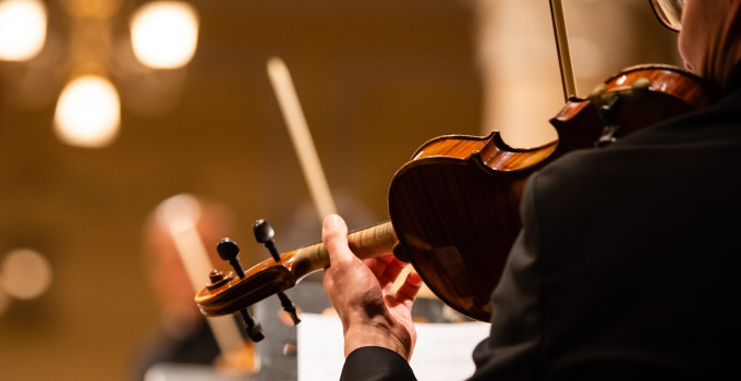 Close-up of a violinist from behind in the orchestra