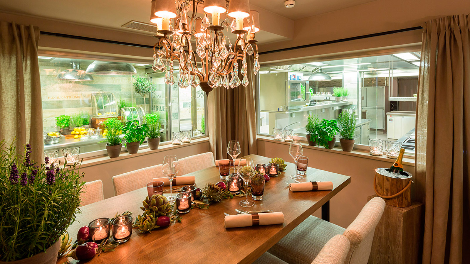 Stilvoll dekorierte Tafel vor einer offenen Küche im Sterne Restaurant im Hotel Vier Jahreszeiten in Hamburg